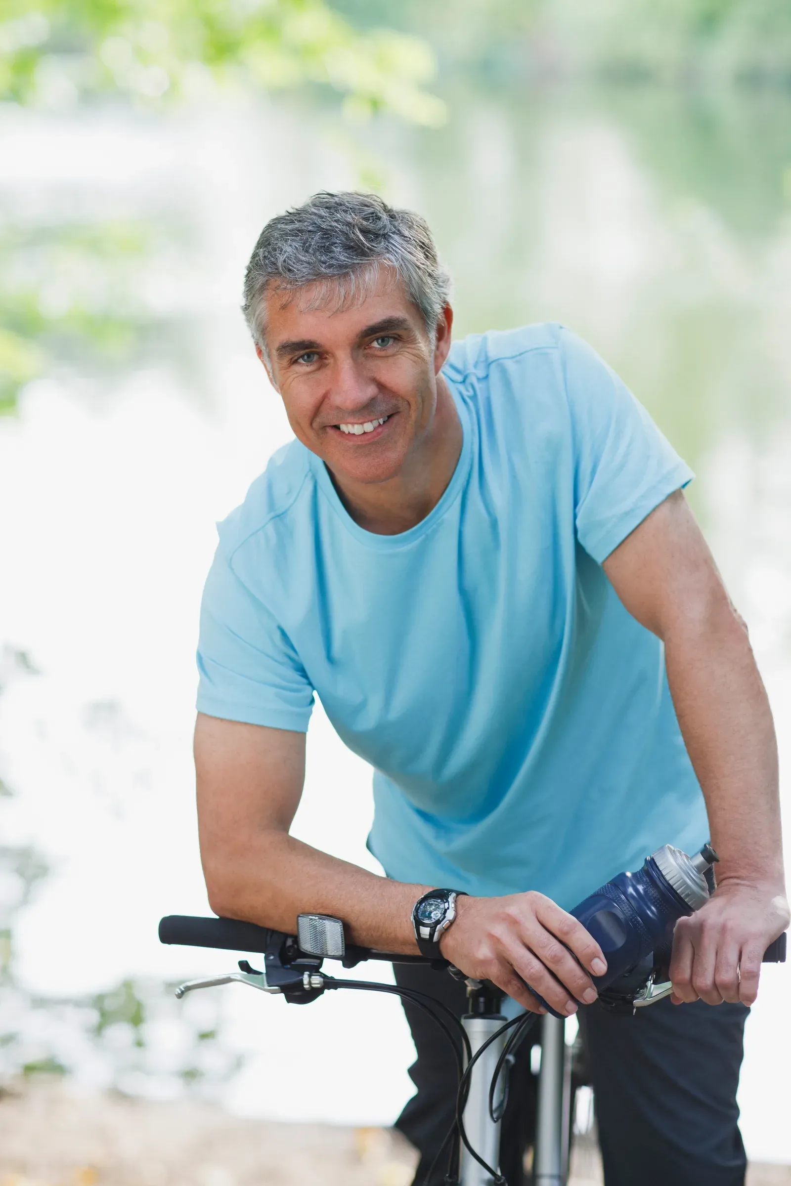 Smiling man in his late forties outdoors in a light blue T-shirt