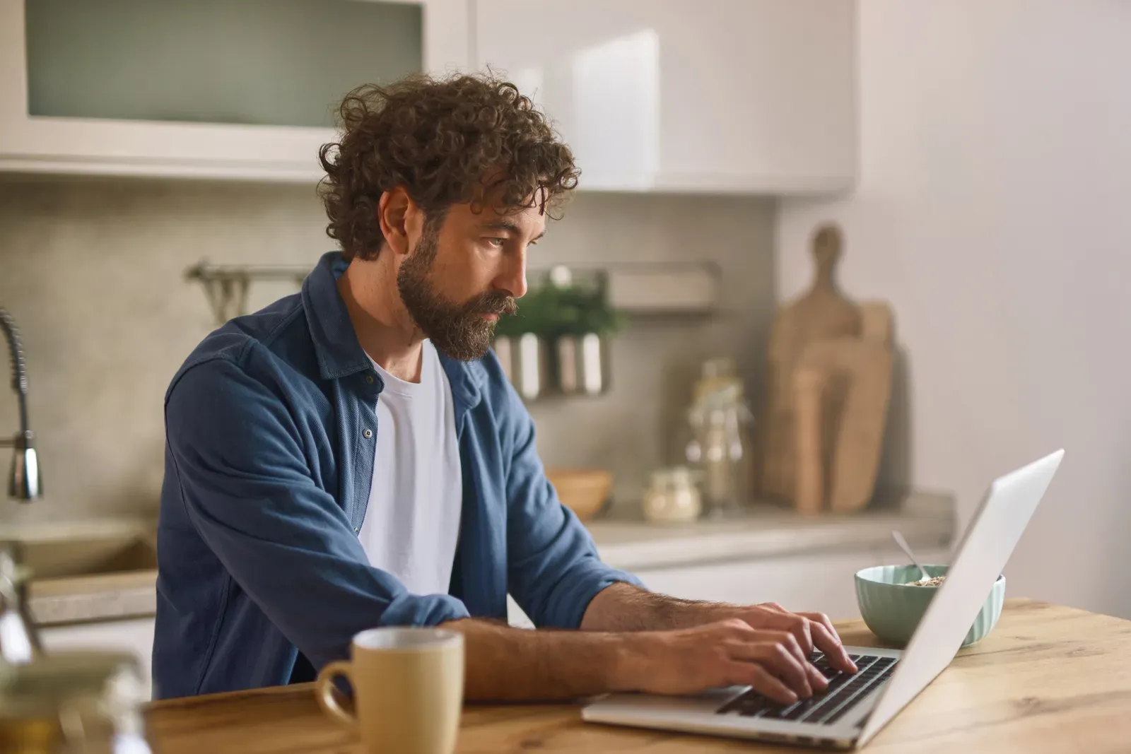 Man working on a laptop at his kitchen counter