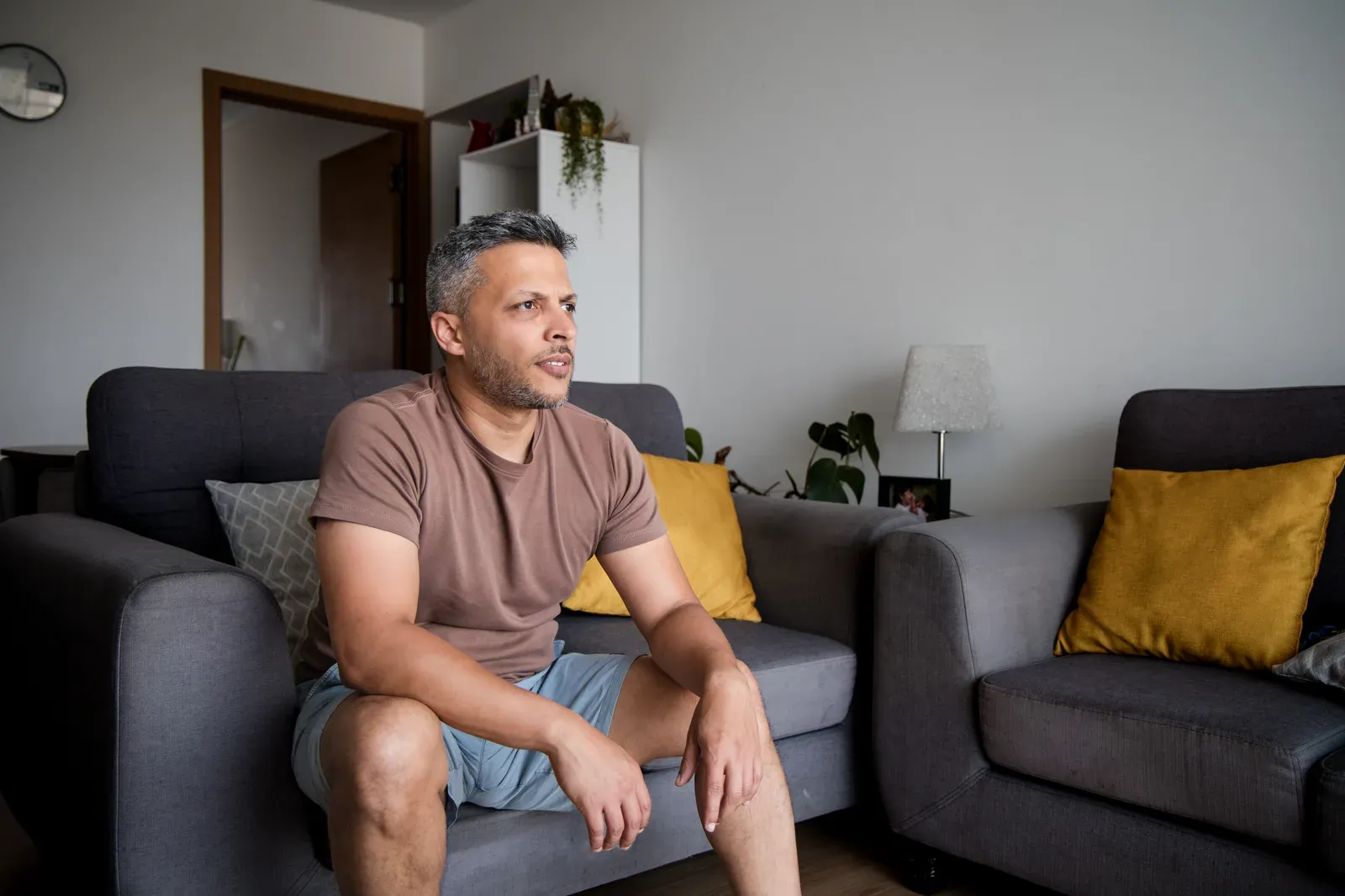 Man in his forties on his couch after a home dumbbell session