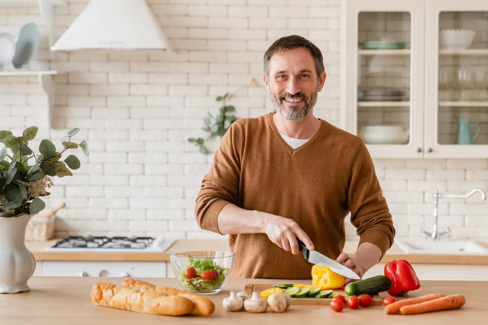 Man in his forties preparing vegetables in a bright kitchen